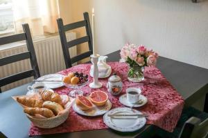 a table with a pink table cloth with food and flowers at Ferienhaus an der Baeke A in Bad Zwischenahn