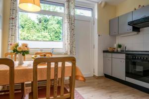 eine Küche mit einem Esstisch und einem Fenster in der Unterkunft Ferienhaus an der Baeke E in Bad Zwischenahn