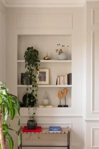 a room with shelves with plants and a table at luxury apartment saint germain des près Paris in Paris