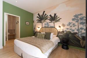 een slaapkamer met een groot bed en een muurschildering van palmbomen bij Les Cotonnades Lorient in Lorient
