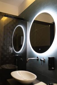 een badkamer met een wastafel en een spiegel bij Kreart Suite & Rooms B&B in Crotone