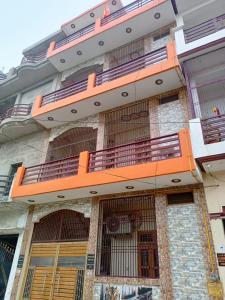 a building with orange balconies on the side of it at Om Home Stay in Ayodhya