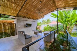 eine Außenterrasse mit Stühlen und Tischen auf dem Balkon in der Unterkunft Al Caribe Sur Villa Privada con 2 Dormitorios y 2 baños in Puerto Viejo