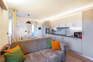 a living room with a couch and a kitchen at La Sorgente Ville di Fiemme in Carano