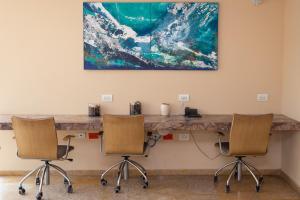 einen Tisch mit zwei Stühlen und ein Gemälde an der Wand in der Unterkunft HOTEL OCEANIA in Cartagena de Indias