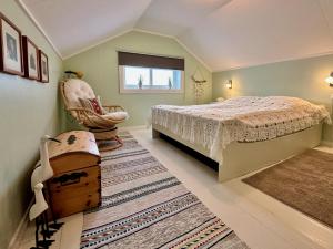 1 dormitorio con 1 cama y 1 silla en Cozy cottage at the Atlantic coast, en Leknes