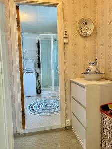 a hallway with a door leading to a room with a refrigerator at Cozy cottage at the Atlantic coast in Leknes