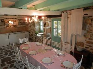 uma sala de jantar com uma mesa rosa e cadeiras em Gîte d'Alexandre 