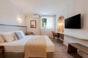 a hotel room with a bed and a flat screen tv at Blue Paradise Studios in Argostoli