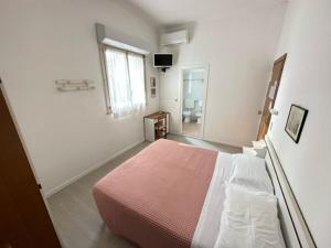 una camera con un grande letto e una finestra di Hotel Fiorenza a Milano Marittima