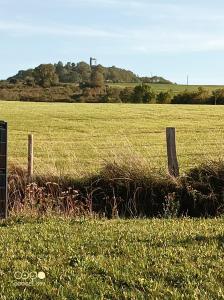 ein Feld mit einem Zaun und einem Grasfeld in der Unterkunft Aux pieds de la colline de Mousson in Pont-à-Mousson