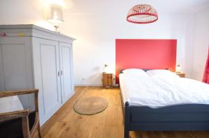 1 dormitorio con 1 cama grande y pared roja en Ein Tag am Meer, en Schashagen