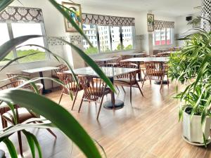 un restaurante con mesas, sillas y macetas en Long Bao Chau Hotel, en Thu Dau Mot
