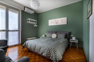um quarto com uma cama e uma parede verde em Casa Carozzi - Carozzi Apartments em Milão