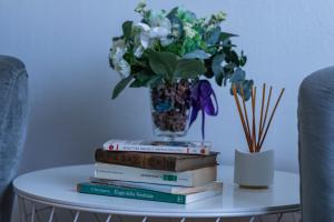 uma mesa com uma pilha de livros e um vaso com flores em Casa Carozzi - Carozzi Apartments em Milão