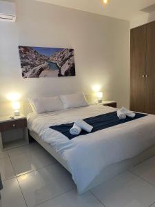 a bedroom with a large bed with towels on it at Msida Suites in Msida
