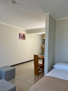 1 dormitorio con cama, escritorio y mesa en Chanos Apart-Hotel, en Barranca