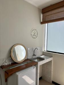 baño con lavabo y espejo en la encimera en Chanos Apart-Hotel, en Barranca