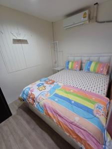 a bedroom with a bed with a colorful comforter at ละเมอ เกสเฮ้าส์ บางแสน ซอย1 in Ban Bang Saen (1)
