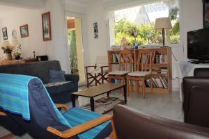 ein Wohnzimmer mit einem Sofa, Stühlen und einem Tisch in der Unterkunft 602 - A ERQUY, jolie maison avec un grand jardin de 700m2 proche des plages sauvages in Erquy