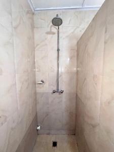 een douche met een douchekop in de badkamer bij Tranquil Room in Apartment in Lusaka