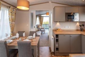 een keuken en eetkamer met een tafel en een eetkamer bij Abingdon Lodge 7 Close to St Andrews in Strathkinness