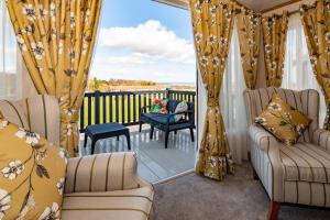 una veranda schermata con 2 sedie e un tavolo di Abingdon Lodge 7 Close to St Andrews a Strathkinness