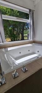 a white bath tub sitting in front of a window at Linaje Hotel Boutique & Relax in Lago Puelo