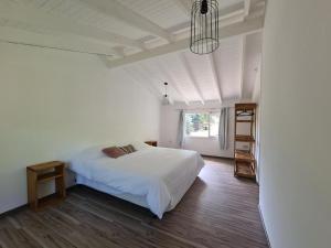 um quarto com uma cama branca e uma janela em Linaje Hotel Boutique & Relax em Lago Puelo