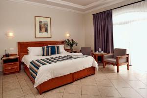 a hotel room with a bed and a chair at Paradise Bay Resort in Mellieħa