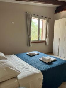 a bedroom with a bed with two towels on it at Casa Ziretto in Castelmola