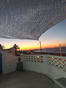 HarqalahにあるVilla dar nina herglaの建物のバルコニーから夕日を望めます。
