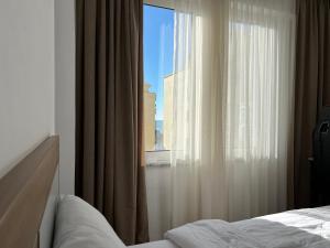 Schlafzimmer mit einem Fenster mit Stadtblick in der Unterkunft Cherry Apartment in Durrës
