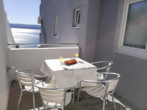 een tafel met stoelen en een bord eten op een balkon bij Apartments Villa ALEN in Mimice