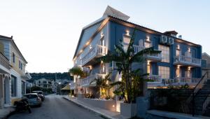 a blue building with a palm tree next to a street at Blue Paradise Studios in Argostoli