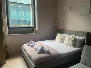 a bedroom with a bed with two dolls on it at Stunning Apartment in Manchester City Centre in Manchester