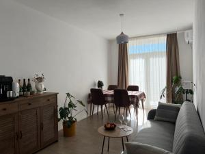 ein Wohnzimmer mit einem Sofa und einem Tisch mit Stühlen in der Unterkunft Cherry Apartment in Durrës