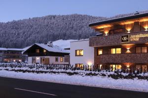 a building on the side of a road with snow at Ferienhaus Streif LXL in Kirchdorf in Tirol