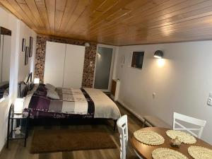 a bedroom with a bed and a table and chairs at Guest House Urlătoarei - Bușteni in Buşteni