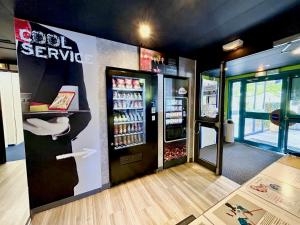 una estación de refrescos con una máquina de refrescos en una tienda en ibis Budget Beaune, en Beaune