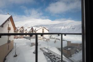 a view of a snow covered mountain from a window at 2-room apartment New Gudauri F1 in Gudauri
