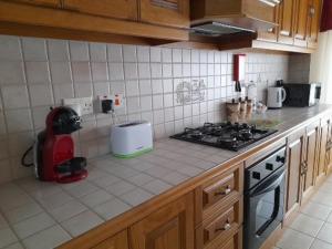 a kitchen with a stove and a counter top at Silver Shadow Holiday Maisonette in Marsaxlokk