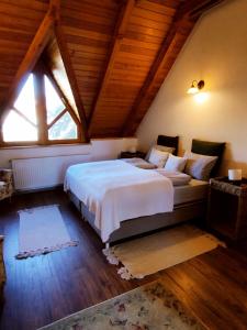 a bedroom with a large bed in a attic at Kiskúti Vendégház in Monoszló