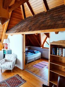 um quarto com uma cama num quarto com tecto em madeira em Kiskúti Vendégház em Monoszló