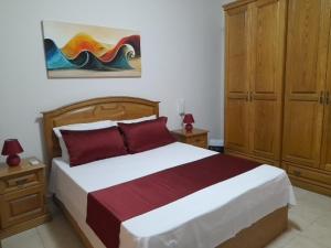 a bedroom with a bed and a painting on the wall at Silver Shadow Holiday Maisonette in Marsaxlokk