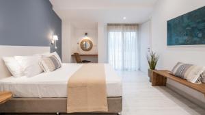 a bedroom with a large white bed and a table at Blue Paradise Studios in Argostoli