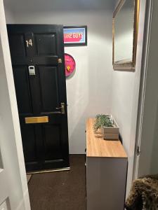 una puerta negra en una habitación con una mesa de madera en C&E Apartment, en Edimburgo