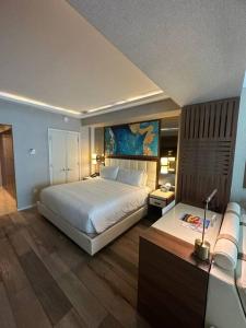 1 dormitorio con 1 cama blanca grande y escritorio en New Serene Condo in Luxury Hotel, en Fort Lauderdale