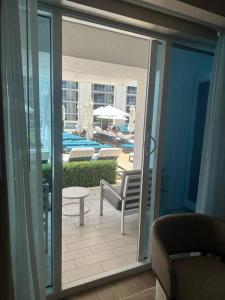 una puerta de cristal abierta a un patio con piscina en New Serene Condo in Luxury Hotel, en Fort Lauderdale