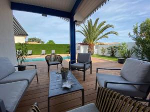 a patio with two couches and a table and chairs at Maison moderne avec piscine in La Teste-de-Buch